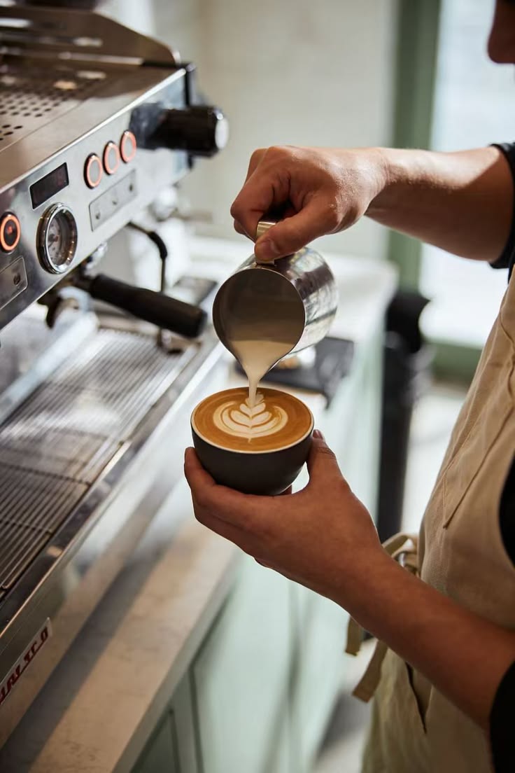 Milk being poured into a cup of coffee